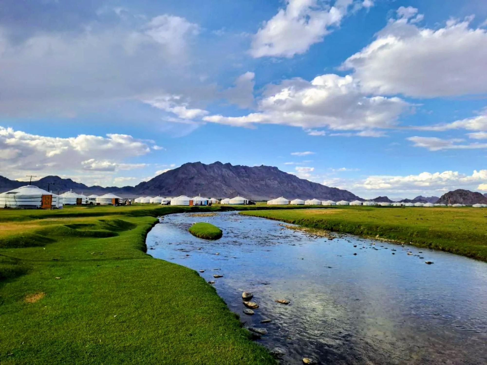 Bilde av helva i Khovd, Mongolia med mange gerer satt opp langs elvebredden