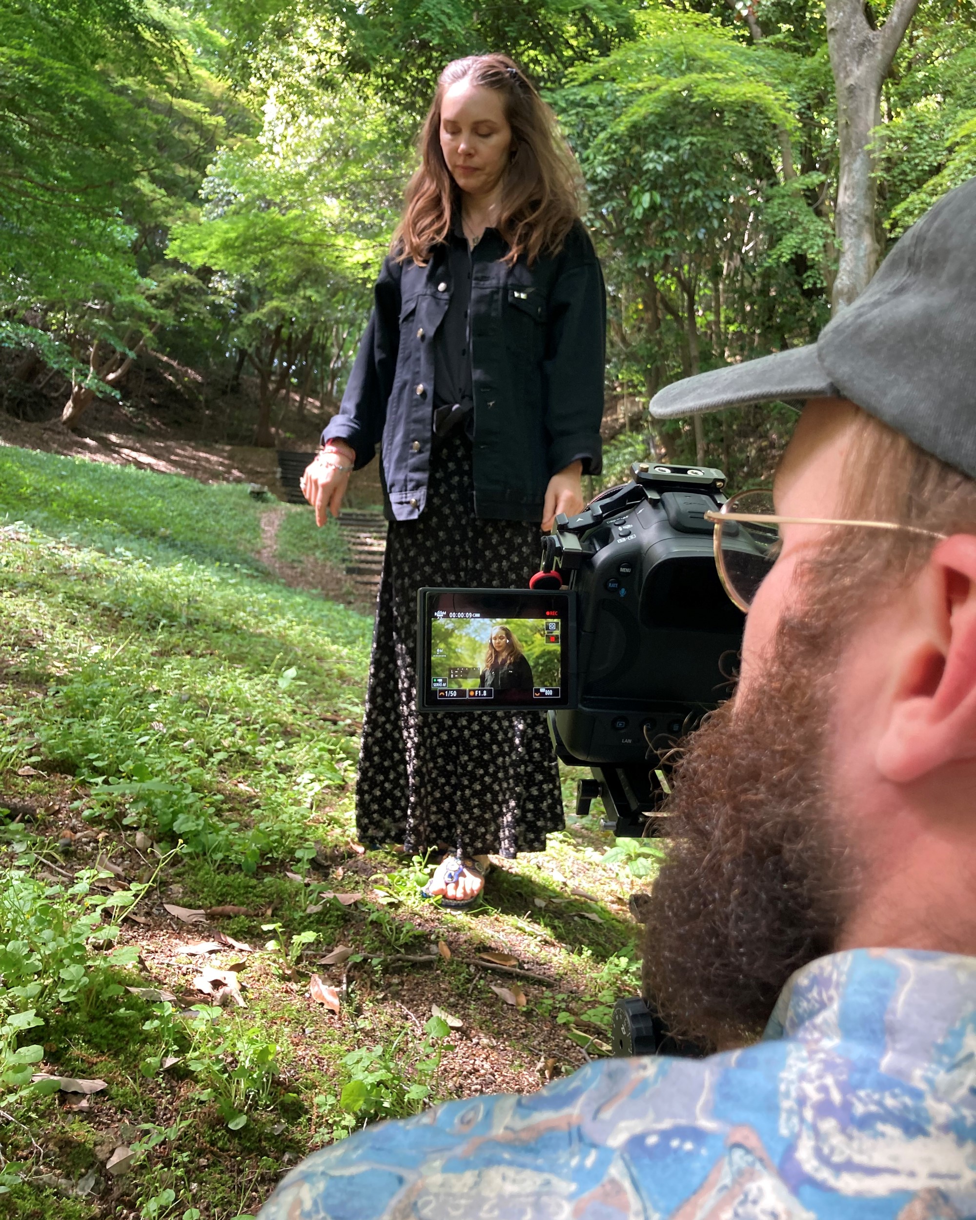 En kvinne i bakgrunnen og en fotograf med kamera i forgrunnen