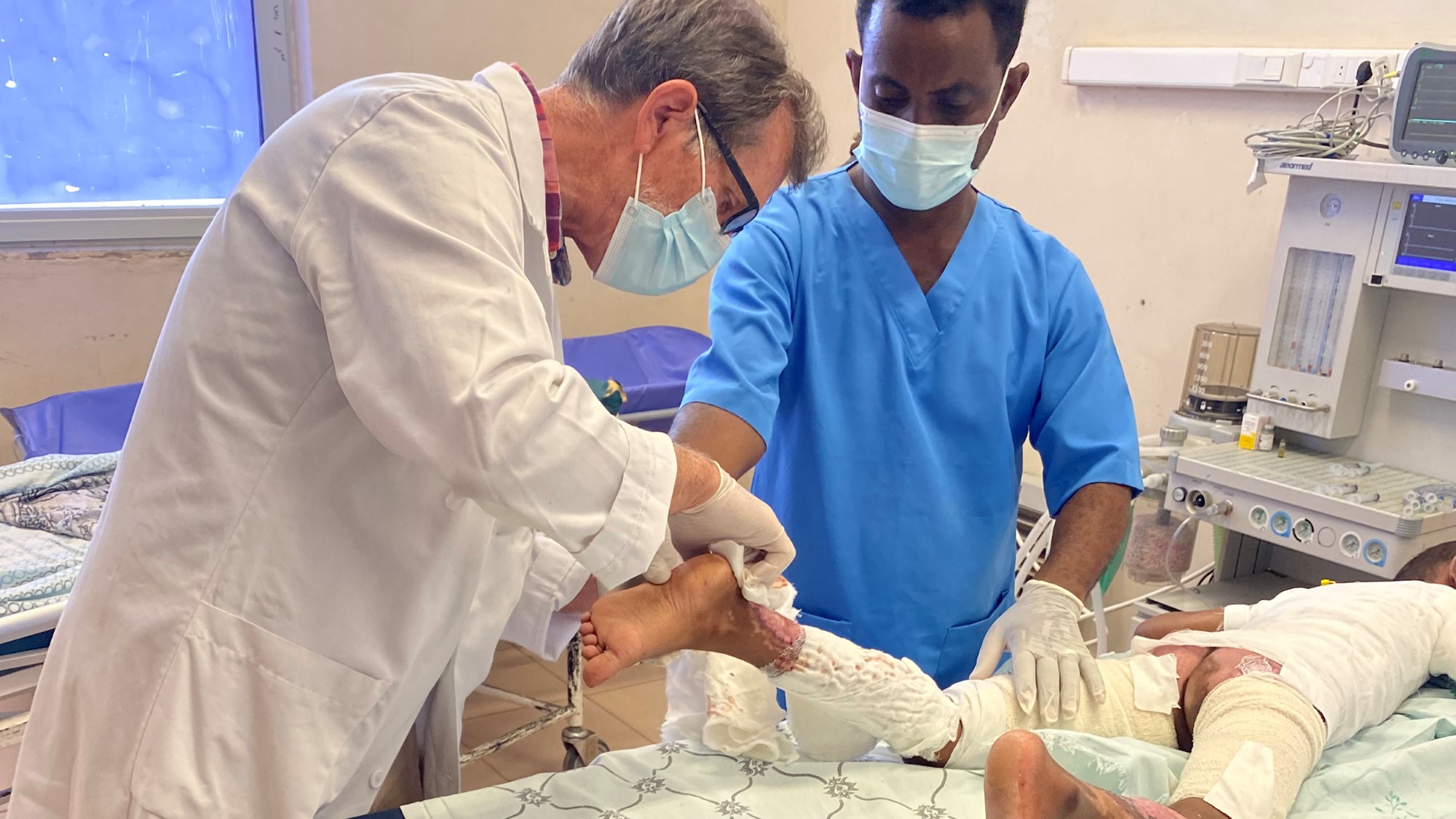 Einar Eriksen og lokal sykepleier i gang med behandling av brannskade.