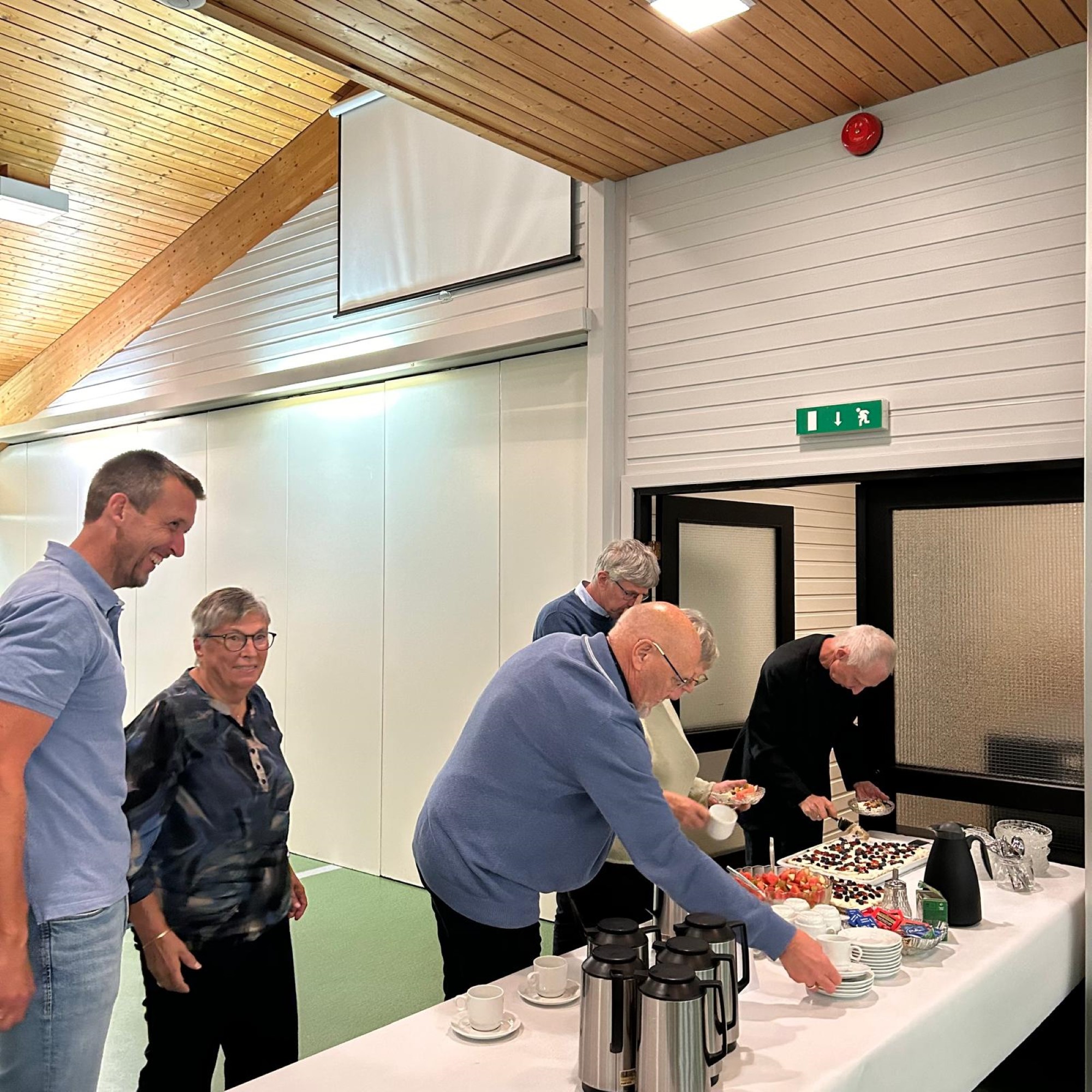 Bildet viser flere personer som forsyner seg med kake