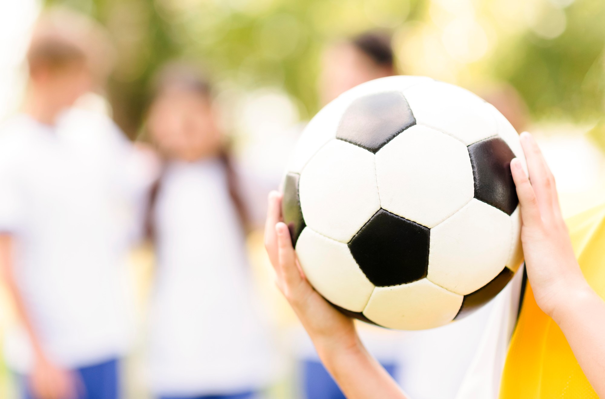 Jente holder fotball, ansikt skjult