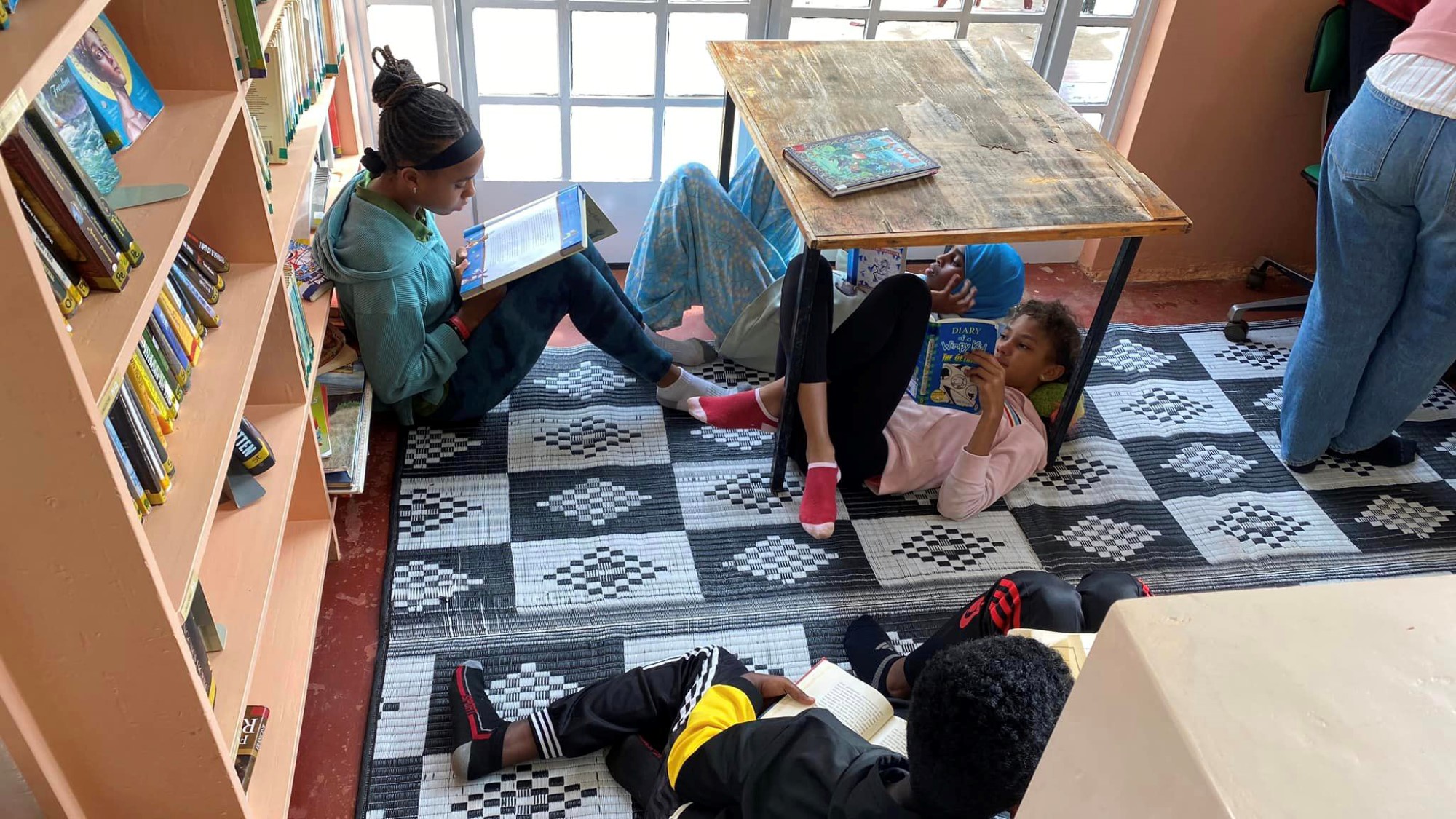 Amani og venner leser bøker i biblioteket