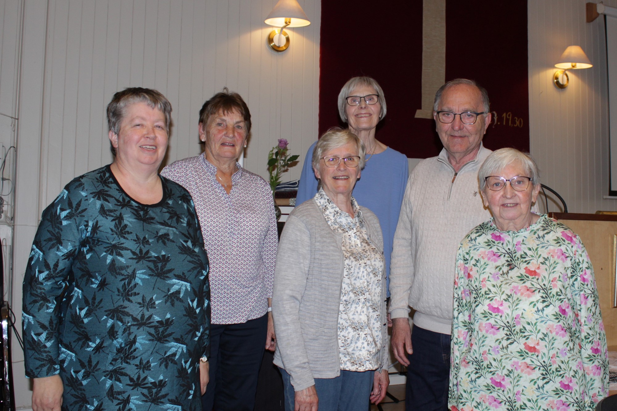 Bildet viser glade mennesker som står samlet.